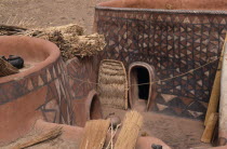 Newly painted traditional mud architecture with woven straw doors and flat rooves.  Walls painted with abstract geometric patterns in red  black and white.Sirigu village.  West Africa