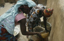 Women filtering water to prevent guinea worm  a parasitic disease contracted when contaminated water is consumed and which can infect stagnant water.West Africa