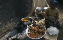 Woman selling stew of guinea-fowl at street food stall.West Africa