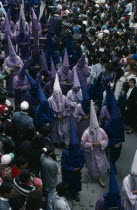 Good Friday procession in Plaza San Francisco.  Penitents wearing purple robes and hoods walk through crowds.Holy Week  Easter