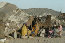 Beja nomad Beni Amer tribeswomen and children from Eritrea outside tent in refugee settlement.