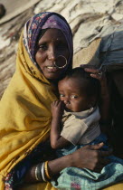 Portrait of Beni Amer Beja nomad woman holding child  refugees from Eritrea.
