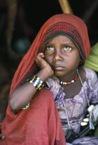 Portrait of Beni Amer Beja nomad refugee girl with chin resting on hand.