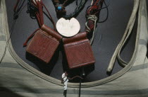 Close view of leather pouches containing verses of the Koran worn around the neck as a charm by Chadian refugee woman together with old French coin and beads.Moslemhijjab