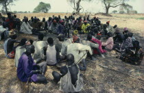 Guests at Dinka wedding listening to traditional story teller. Indigenous Marriage
