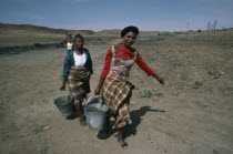 Women carrying buckets of water
