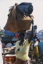 Camp for Sierra Leonean Refugees. Woman carrying sack on her head arriving in camp.