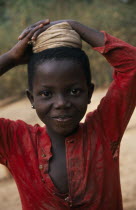 Portrait of young girl with coiled cloth on her head for carrying water pot.