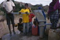 Ouna Watot camp for people displaced by war with Ethiopia.  Women and children at water pump.refugee