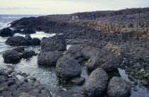 Visitors on rocky promontory of North West Moyle coast consisting of thousands of polygonal colimns of basalt attributed to rapidly cooling lava.Eire Republic Eire Republic Eire Republic Eire Repu...
