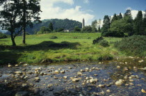 Ruins of St Kevin s monastery  dating from the Sixth Century set in rural landscape with stream in the foreground.Eire Republic Eire Republic Eire Republic Eire Republic Eire Republic