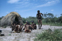 Bushmen tribespeople outside thatched domed hut.African Namibian Southern Africa