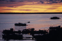 Pink  orange and purple sunset over the waterfront with boats at a pier. Brasil