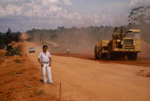 Chico stands near a yellow digger on the BR 364 road  which he campaigned against. Brasil