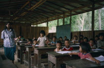 A teacher and pupils in a school class room. Lessons are taught in Chinese and it is financed by the Taiwan government. Burma