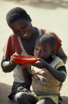 Mother and child at feeding centre for displaced people run by World Vision Aid charity.refugee Center African Eastern Africa Kids Mozambiquean Mum Children