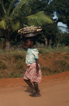 Young girl carrying cut lengths of sugar cane on her head. African Eastern Africa Kids Mozambiquean Immature