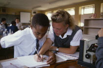 Black and white pupils working together in the classroom. mixed racemulti cultural African Kids Learning Lessons Teaching