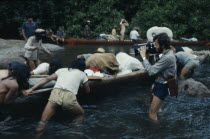 Expedition canoeing down river past Kreen-Akrore fish traps and rapids.Explorers