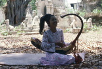 Female musician playing Burmese harp. Burma
