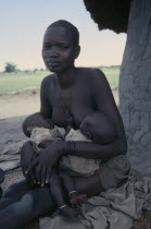 Dinka mother breastfeeding twin babies.