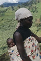 Traditional Ghanaian way of holding baby in printed cotton sling on back.