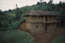 Two storey mud brick house with thatched roof in rural area near Mbale.