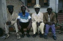 Four Malange chiefs seated and wearing different hats.