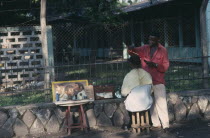 Street barber with customer.  Zaire