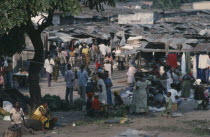 Busy market scene with people and lines of stalls with corrugated iron rooftops. Zaire