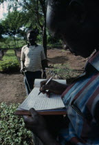 Forestry field assistant Joseph Wanjohia collecting Kamba dialect names and associations of trees.Tree folkloreOral literature
