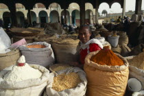 Woman selling spices  beans and lentils at market.