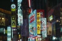 Neon shop signs illuminated at night.