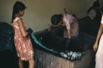 Girls dyeing batik cloth.
