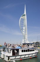The Spinnaker Tower the tallest public viewing platforn in the UK at 170 metres on Gunwharf Quay with harbour tour boat entering the moorings