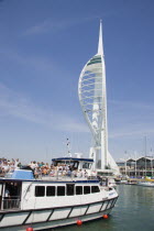 The Spinnaker Tower the tallest public viewing platforn in the UK at 170 metres on Gunwharf Quay with harbour tour boat entering the moorings