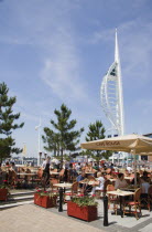 The Spinnaker Tower the tallest public viewing platforn in the UK at 170 metres on Gunwharf Quay with outdoor restaurant seating in the foreground