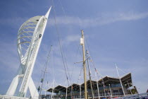 The Spinnaker Tower the tallest public viewing platforn in the UK at 170 metres on Gunwharf Quay with yachts mast in the foreground and waterfront attractions behind