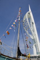 The Spinnaker Tower the tallest public viewing platforn in the UK at 170 metres on Gunwharf Quay with flag decorated yachts mast in the foreground