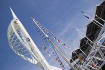 The Spinnaker Tower the tallest public viewing platforn in the UK at 170 metres on Gunwharf Quay with flags decorating a yachts rigging in the foreground