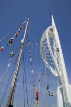 The Spinnaker Tower the tallest public viewing platforn in the UK at 170 metres on Gunwharf Quay with flags decorating a yachts rigging in the foreground