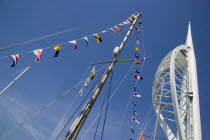 The Spinnaker Tower the tallest public viewing platforn in the UK at 170 metres on Gunwharf Quay with flags decorating a yachts rigging in the foreground