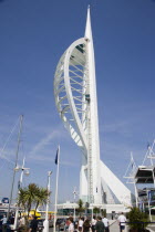 The Spinnaker Tower the tallest public viewing platforn in the UK at 170 metres on Gunwharf Quay with people walking along the waterfront area