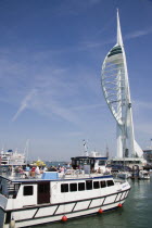 The Spinnaker Tower the tallest public viewing platforn in the UK at 170 metres on Gunwharf Quay with harbour tour boat entering moorings