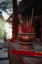 Temple of Literature founded in 1070 by Emperor Ly Thanh Tong and dedicated to Confucius.  Interior detail of altar with bowl of burning incense.