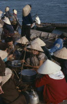 Waterside food stall and customers eating at market.