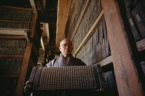 Temple of Haeinsa.  Monk with one of the Tripitaka Koreana  the most complete collection of Buddhist texts engraved on 80 000 woodblocks 1237-1248