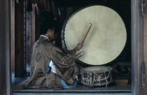 Izumo.  Priests striking large drum during worship at Izumo-Taisha one of the oldest Shinto shrines in the country dedicated to Okuninushi-no-Mikoto.