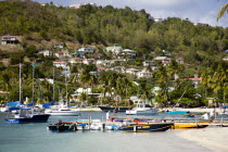 Jetty with moored yachts in Admiralty Bay with hillside houses beyond in Port Elizabeth