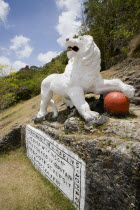 Imperial lion carved from coral rock by British soldiers serving at Gun Hill signal station with the station on the hill in the distance